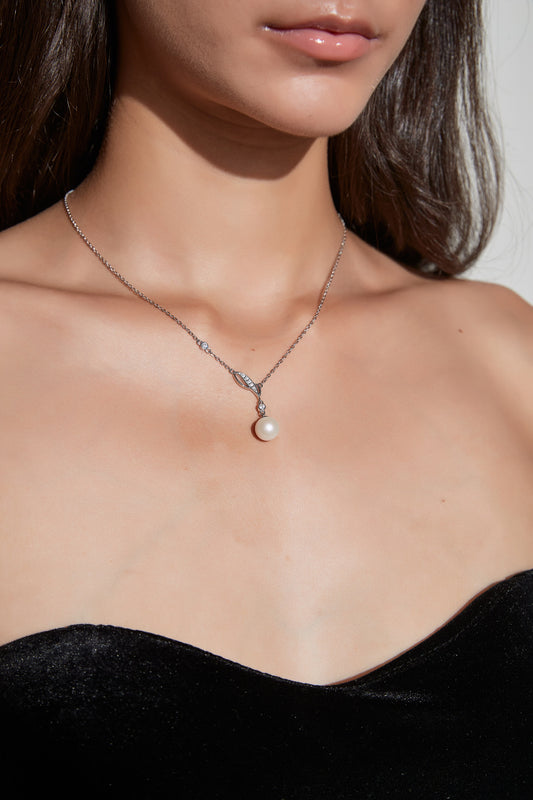 Willow Dew freshwater pearl pendant necklace worn at the neckline, with a leaf-shaped sterling silver detail and cubic zirconia accents.