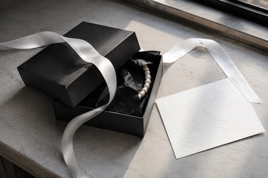 Pearl jewelry with a black gift box and white ribbon