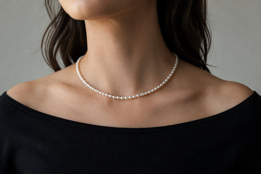 Pearl necklace styled with a black boat-neck top
