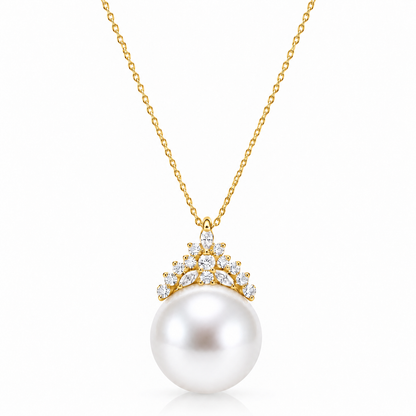 Gold freshwater pearl crown pendant necklace with clear accent stones on a white background
