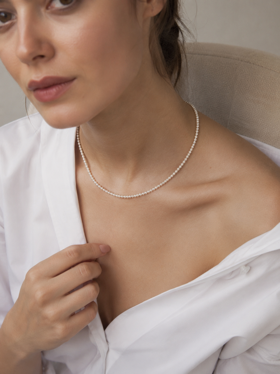 Woman wearing a 3 to 4 mm freshwater pearl collarbone necklace with a white shirt