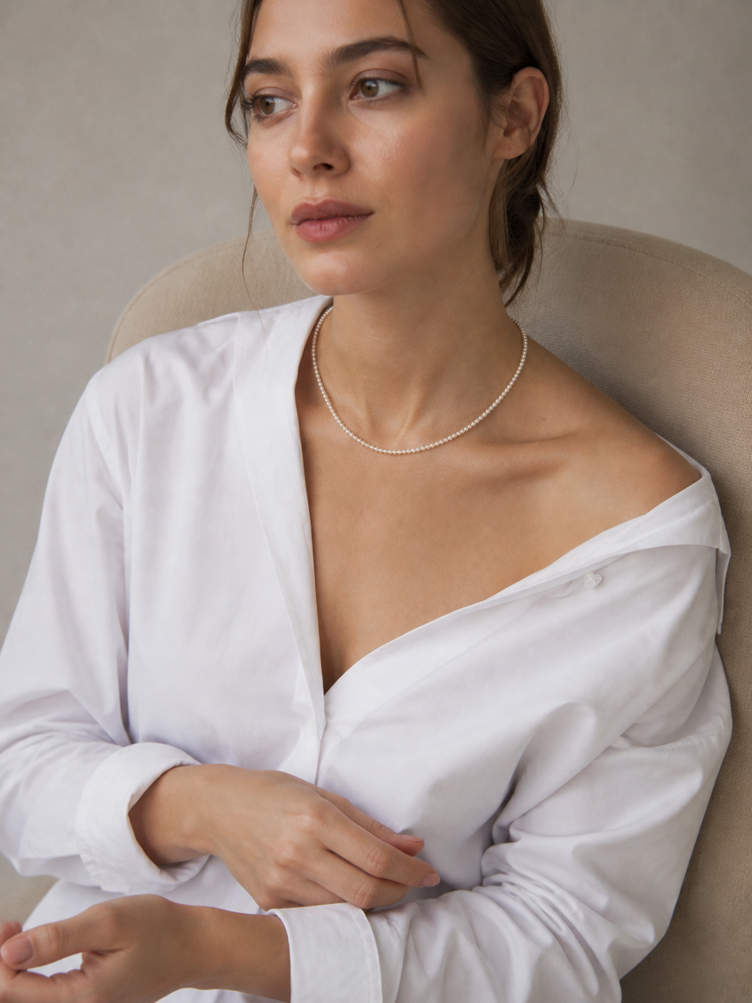 Woman in a white shirt wearing a small freshwater pearl strand necklace