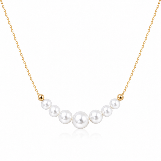 Gold-tone S925 sterling silver necklace with seven graduated round white freshwater pearls on a white background