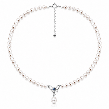 Freshwater pearl necklace with a sterling silver butterfly, blue cubic zirconia and pearl drop on a white background