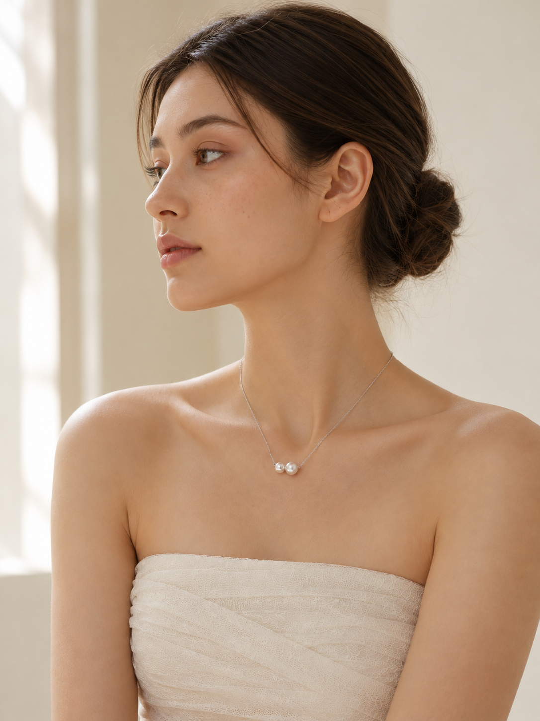 Model wearing the freshwater pearl duo necklace in silver, shown from the side