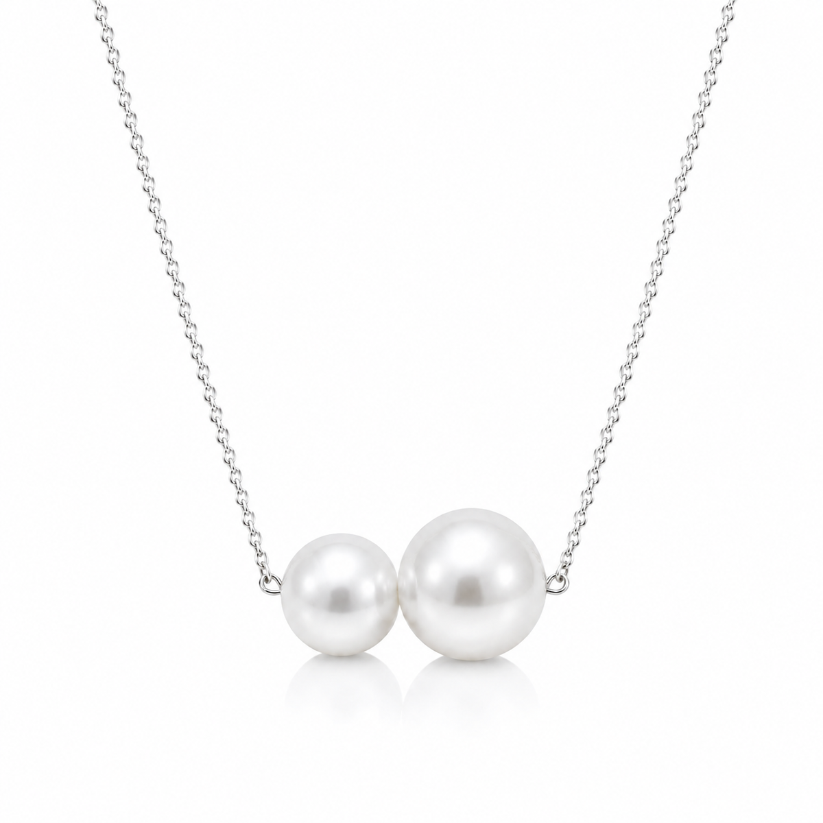 Two round white freshwater pearls on a delicate sterling silver chain, shown on a white background