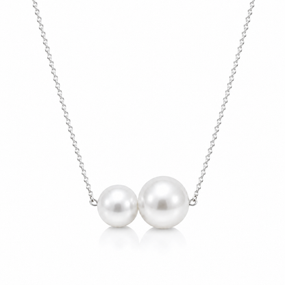 Two round white freshwater pearls on a delicate sterling silver chain, shown on a white background
