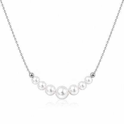 Silver S925 necklace with seven graduated round white freshwater pearls on a white background