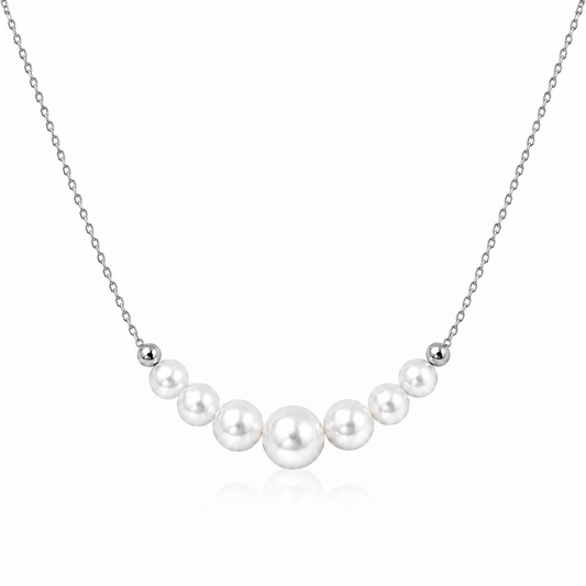Silver S925 necklace with seven graduated round white freshwater pearls on a white background