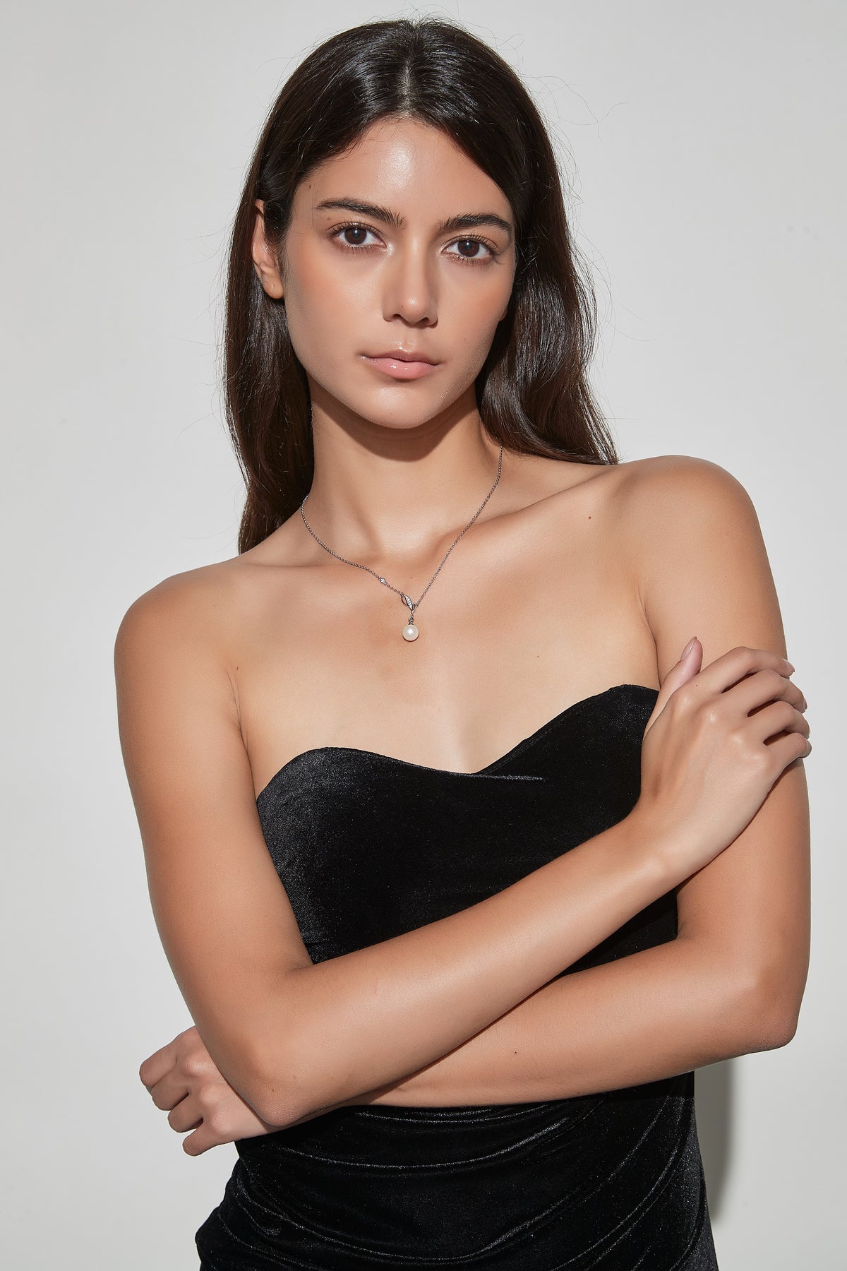 Model wearing the Willow Dew freshwater pearl pendant necklace in sterling silver with a black strapless dress.
