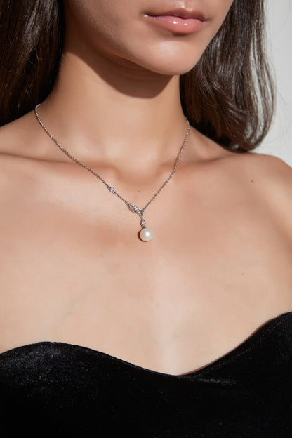 Willow Dew freshwater pearl pendant necklace worn at the neckline, with a leaf-shaped sterling silver detail and cubic zirconia accents.